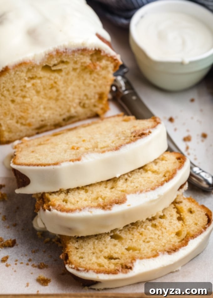 Velvety Cream Cheese Topping 7 Slices of glazed peach loaf cake arranged neatly on a parchment-lined tray, ready to be served.