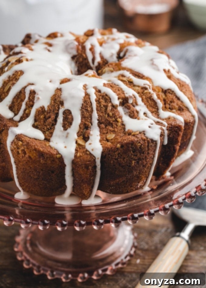 Simple Powdered Sugar Glaze 2 cinnamon coffee cake on a pink glass cake pedestal, drizzled with powdered sugar glaze