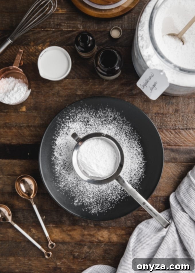 Simple Powdered Sugar Glaze 3 powdered sugar in a sifter sitting in a black bowl on a wood board
