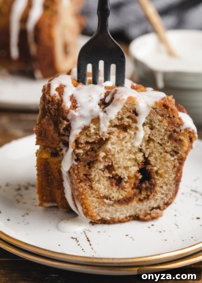 Simple Powdered Sugar Glaze 7 slice of cinnamon swirl coffee cake on a white plate with a black fork