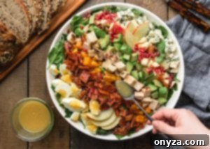 A freshly composed Harvest Cobb Salad with a drizzle of vinaigrette on top, ready to be served.