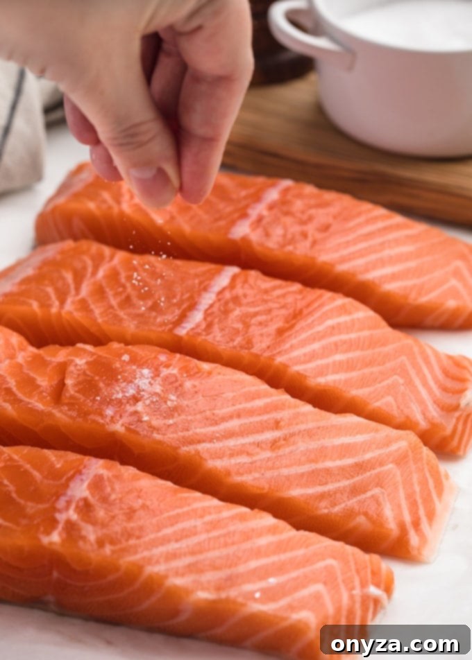 sprinkling kosher salt onto salmon fillets