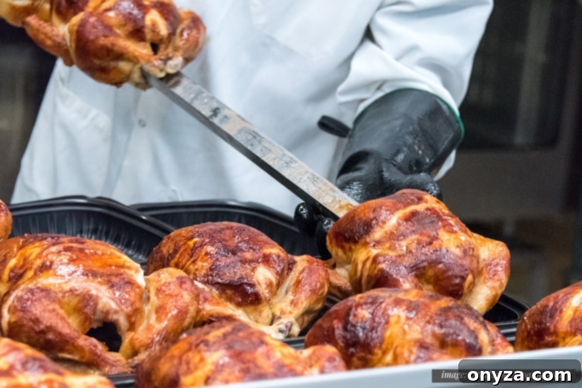 store worker wearing gloves and a white coat removing cooked rotisserie chickens from the spits