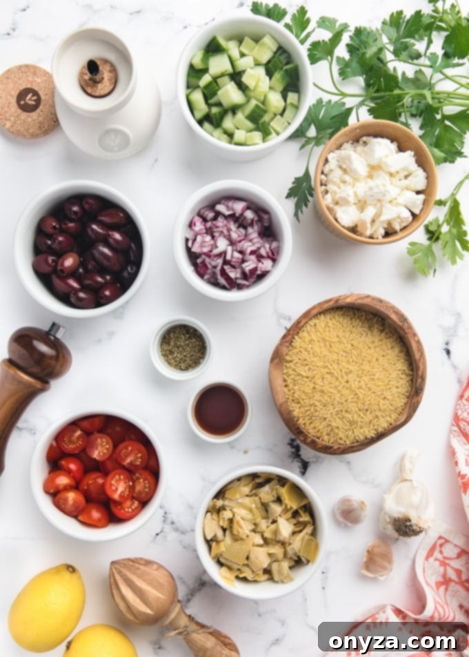 Zesty Feta Orzo Salad 3 Overhead view of various fresh ingredients for Orzo Salad, including diced cucumbers, cherry tomatoes, olives, red onions, and feta cheese, neatly arranged in bowls on a white marble board.