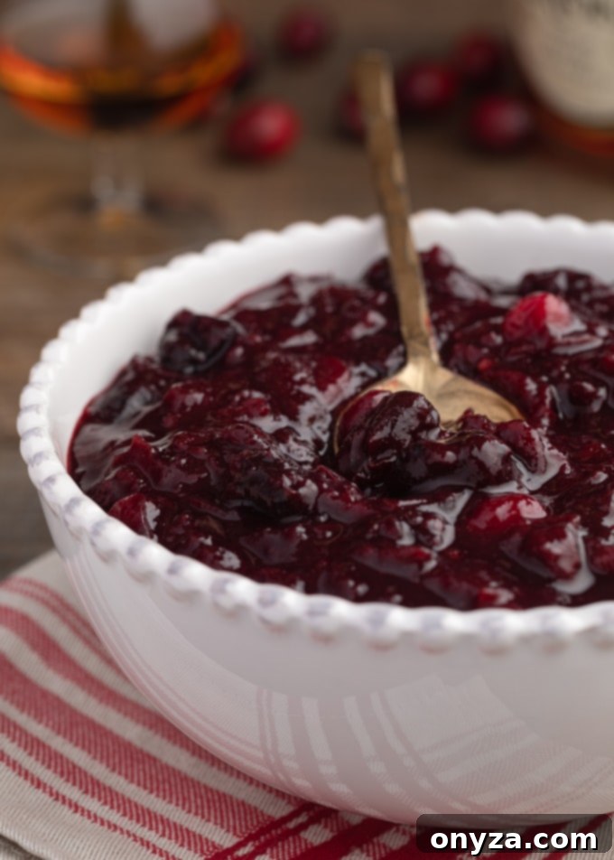 cherry cranberry sauce with brandy in a white ceramic bowl on a red striped napkin