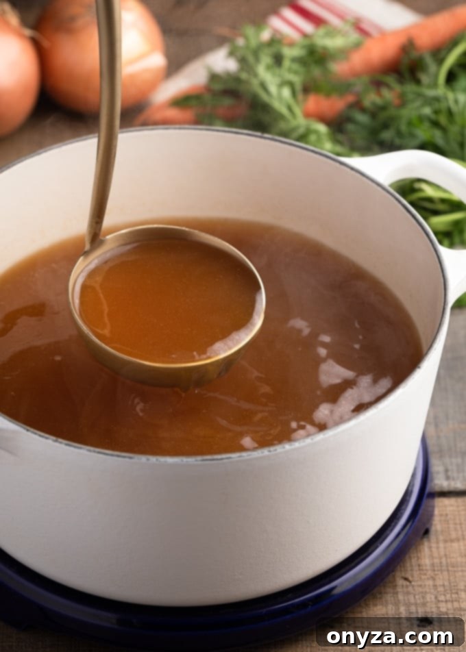 A ladleful of hot, golden turkey stock pouring into a pristine white pot, signifying warmth and homemade goodness.