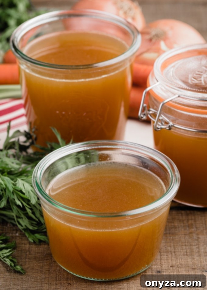Three clear glass jars filled with golden, homemade turkey stock, perfectly chilled and ready for storage.