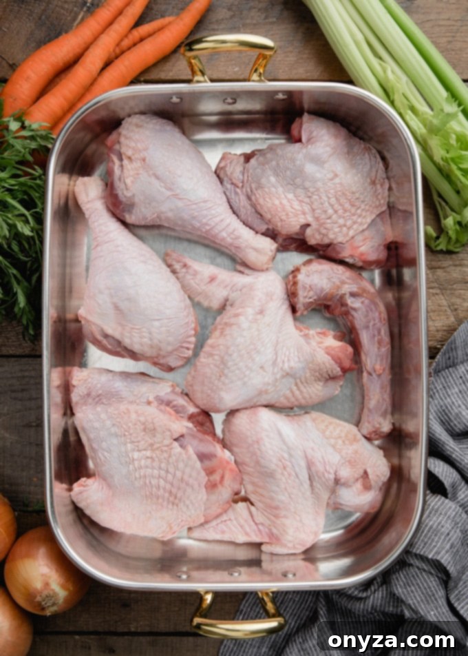 A copper roasting pan filled with raw turkey drumsticks, wings, and thighs, ready for roasting to build rich flavor.