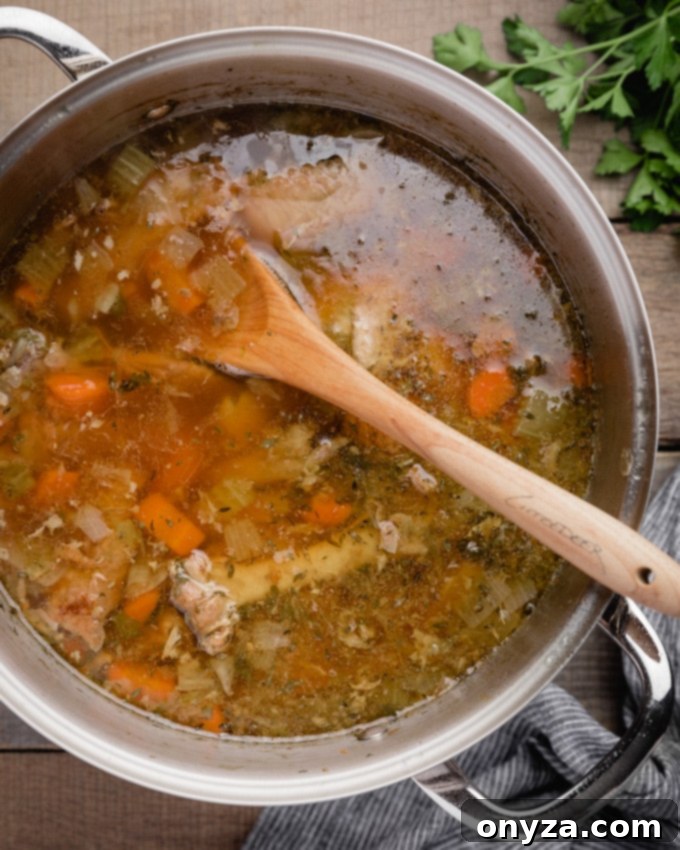 An overhead shot of homemade make-ahead turkey stock after four hours of simmering, deep amber and inviting.