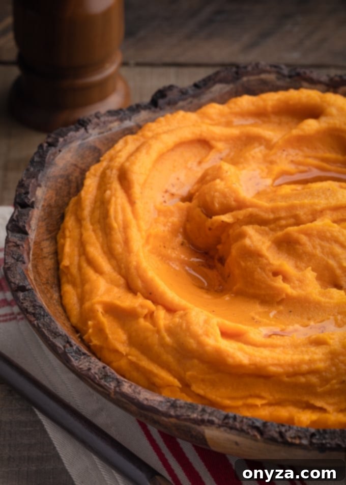 Velvety Brown Butter Sweet Potatoes 2 A wooden bowl filled with creamy brown butter whipped sweet potatoes, garnished for a festive presentation.
