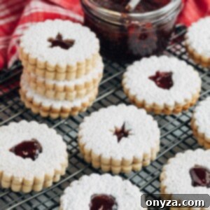 raspberry jam filled Linzer cookies on a wire cooling rack