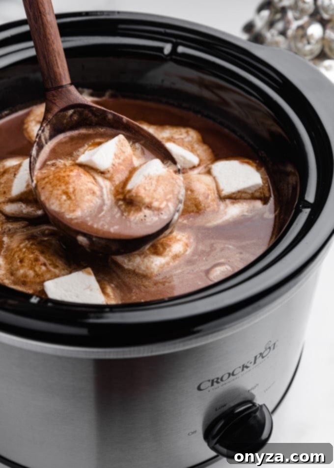 ladleful of slow cooker hot chocolate with melted marshmallows