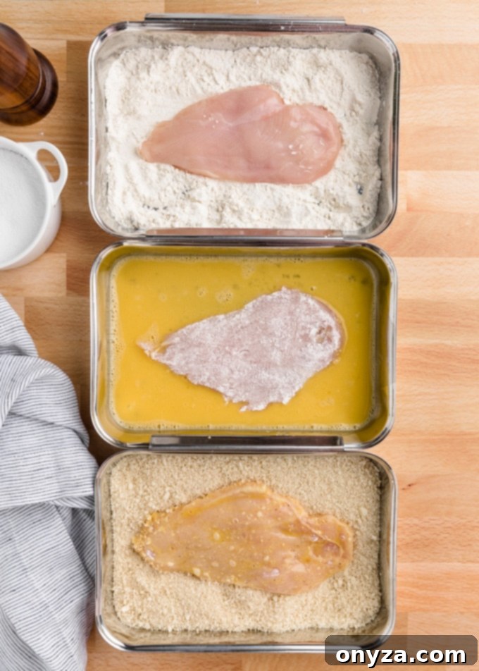 Stovetop and Air Fryer Chicken Milanese 4 chicken cutlets in 3 breading trays: flour, egg wash, and panko breadcrumbs