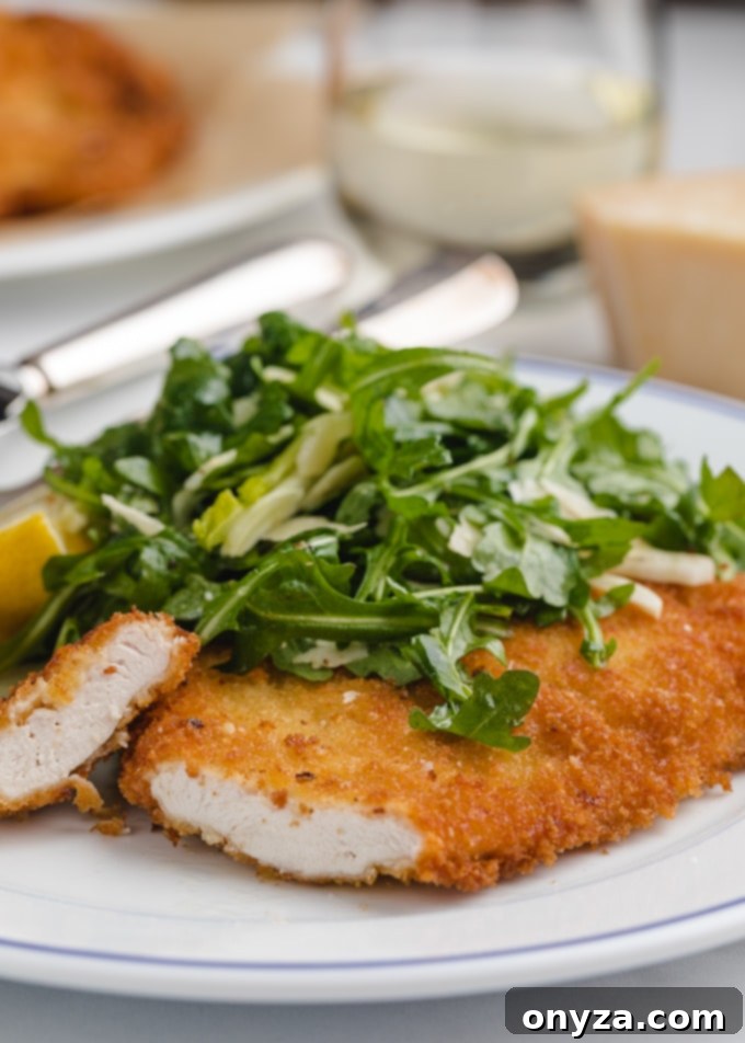 Stovetop and Air Fryer Chicken Milanese 7 sliced chicken milanese cutlet on a white plate
