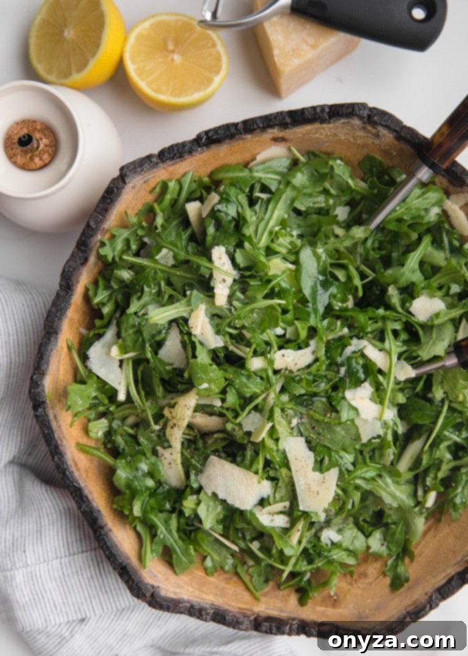 An overhead view of a perfectly dressed arugula and shaved fennel salad, artfully arranged in a rustic wooden bowl, ready to be served.