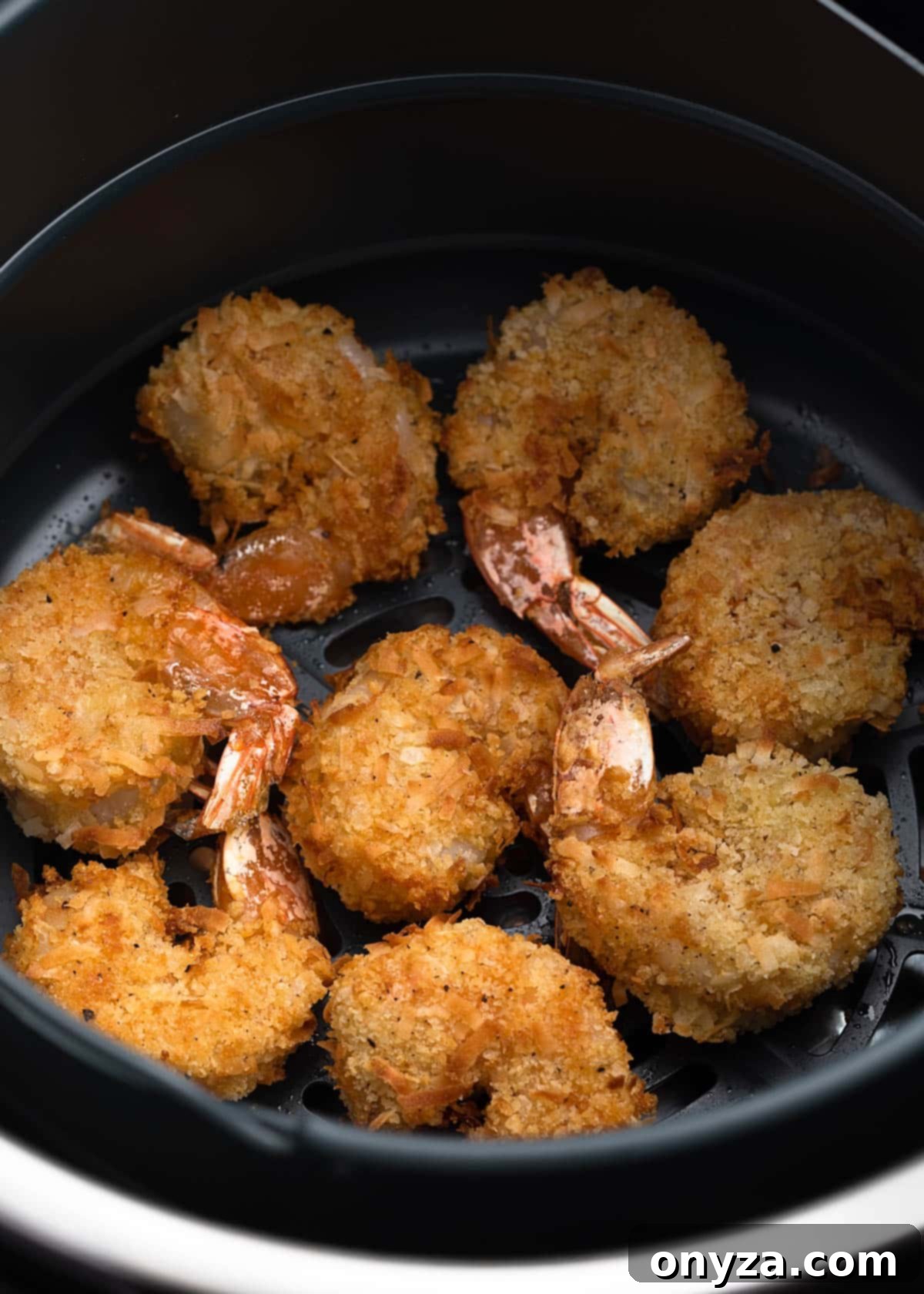 Tropical Crispy Prawns 11 Perfectly air-fried coconut shrimp, golden and crispy, nestled in an air fryer basket.
