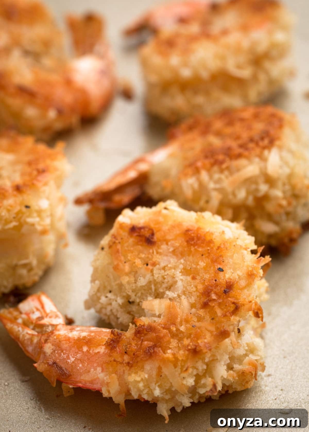 Tropical Crispy Prawns 10 Golden-brown baked coconut shrimp arranged on a baking sheet, showcasing their lighter yet crispy texture.