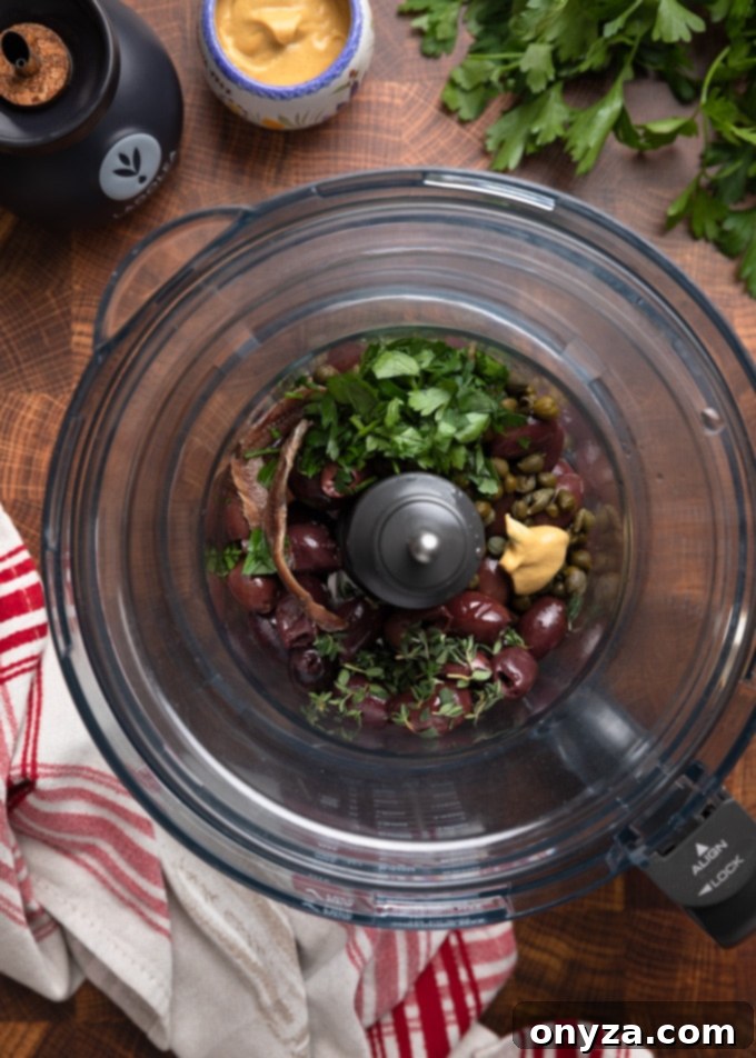 Savory Olive Spread 4 black olive tapenade ingredients in the bowl of a food processor