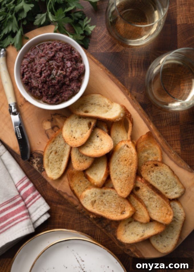 Savory Olive Spread 6 tapenade served with crostini on a wood board