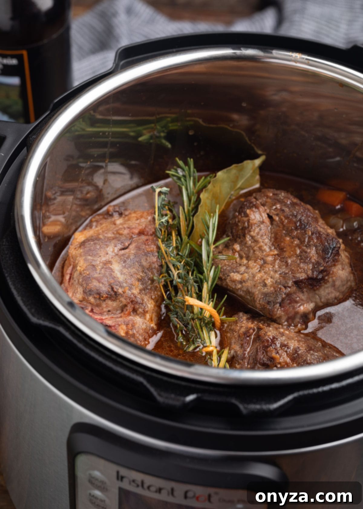 Seared short ribs with stout braising liquid in an electric pressure cooker, ready for quick tenderization