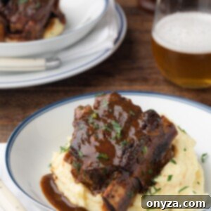 Stout Beer Braised Short Rib in a white serving bowl over mashed potatoes