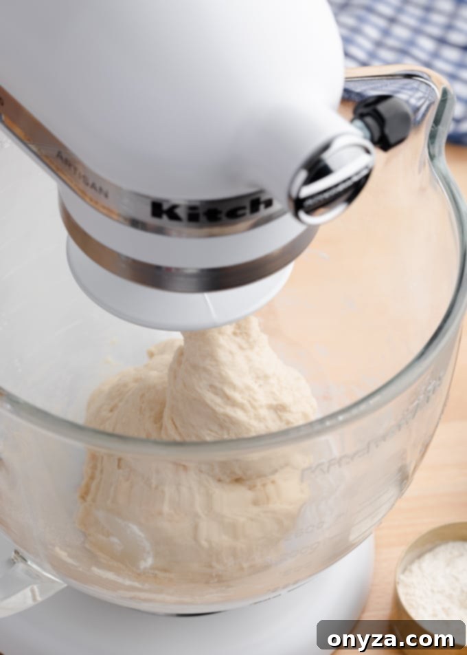 white bread dough in a stand mixer after the initial mixing