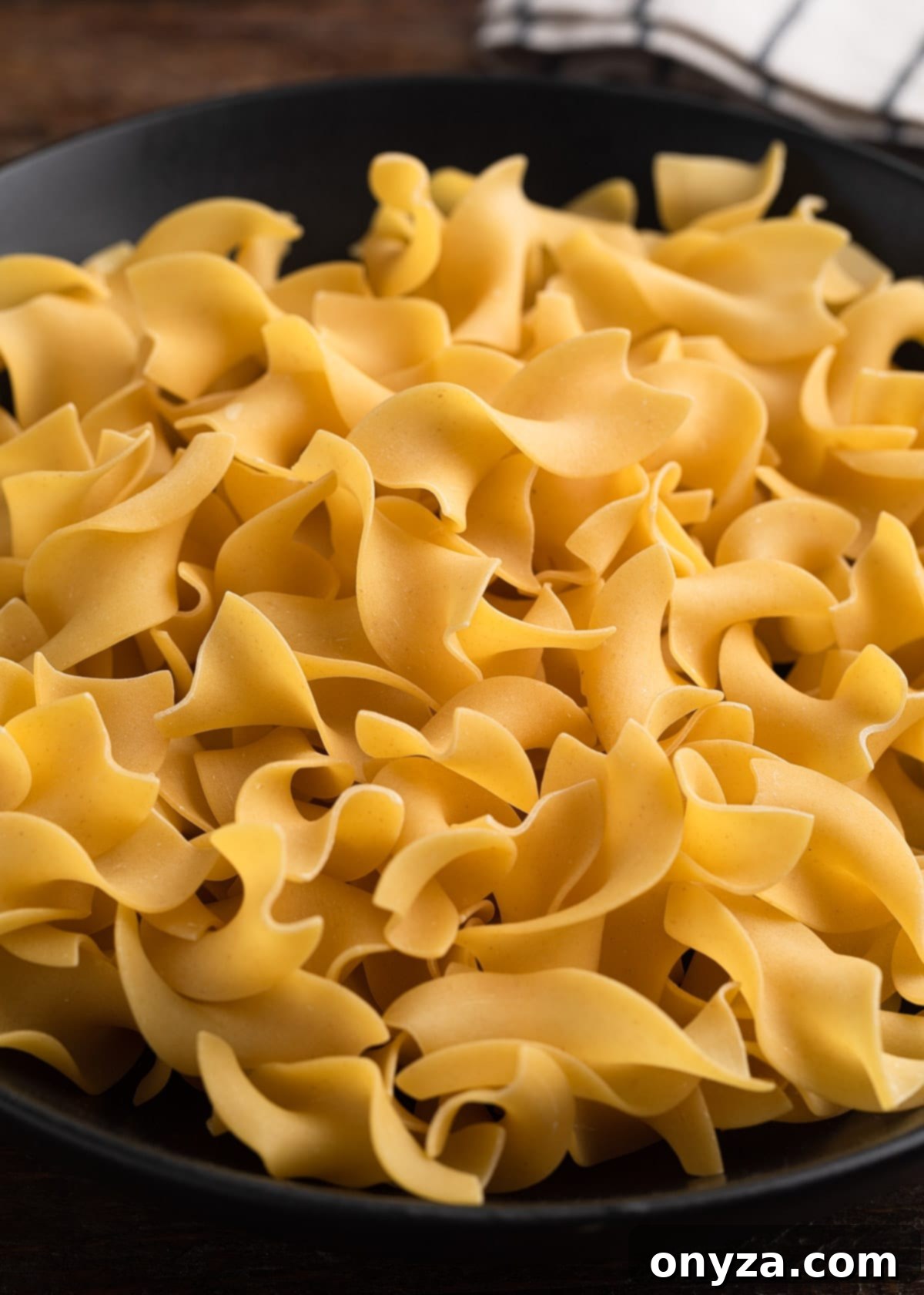closeup of extra wide egg noodles in a bowl