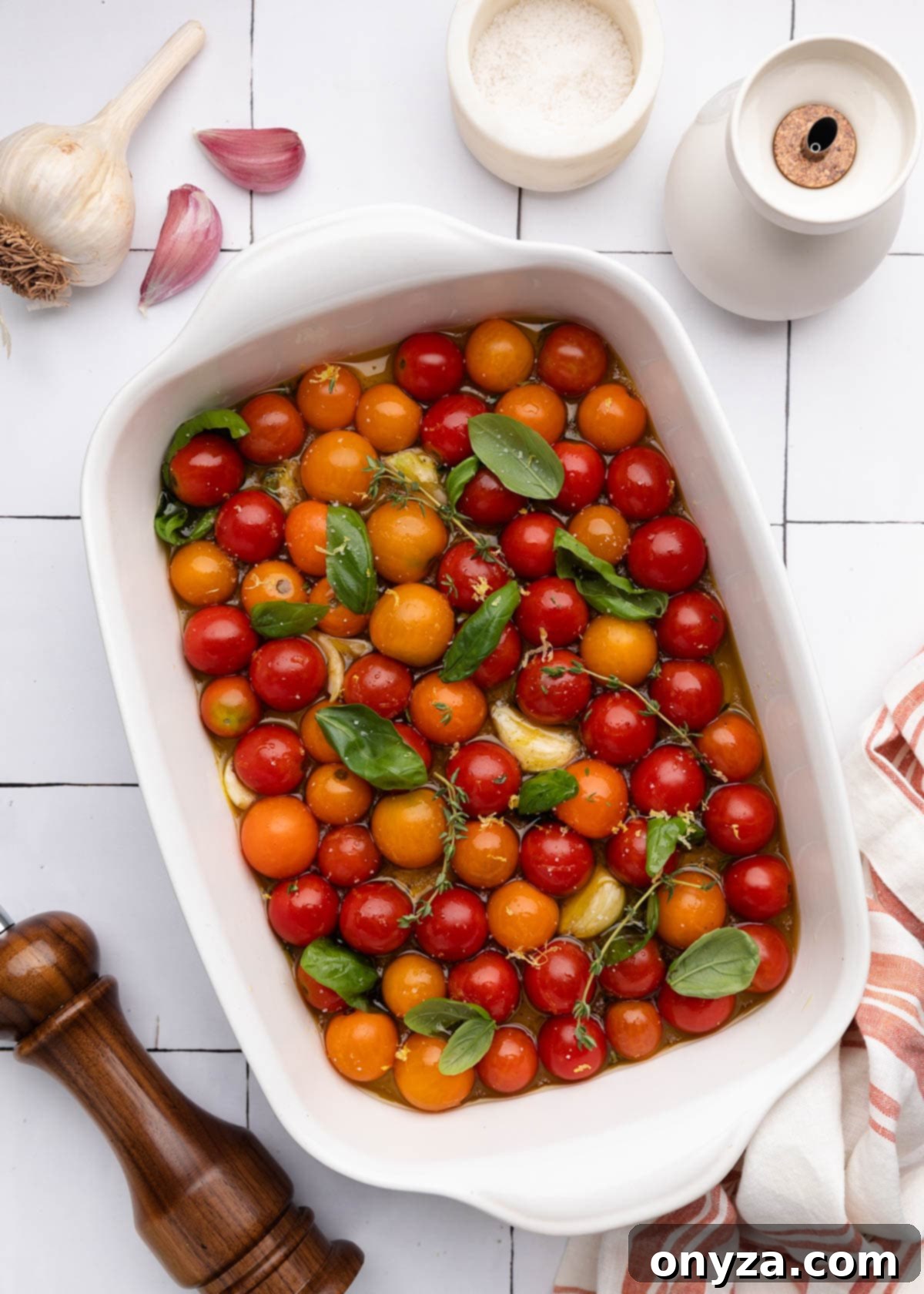 Garlic Herb Cherry Tomato Confit 6 overhead of cherry tomatoes in a white ceramic baking dish with fresh herbs