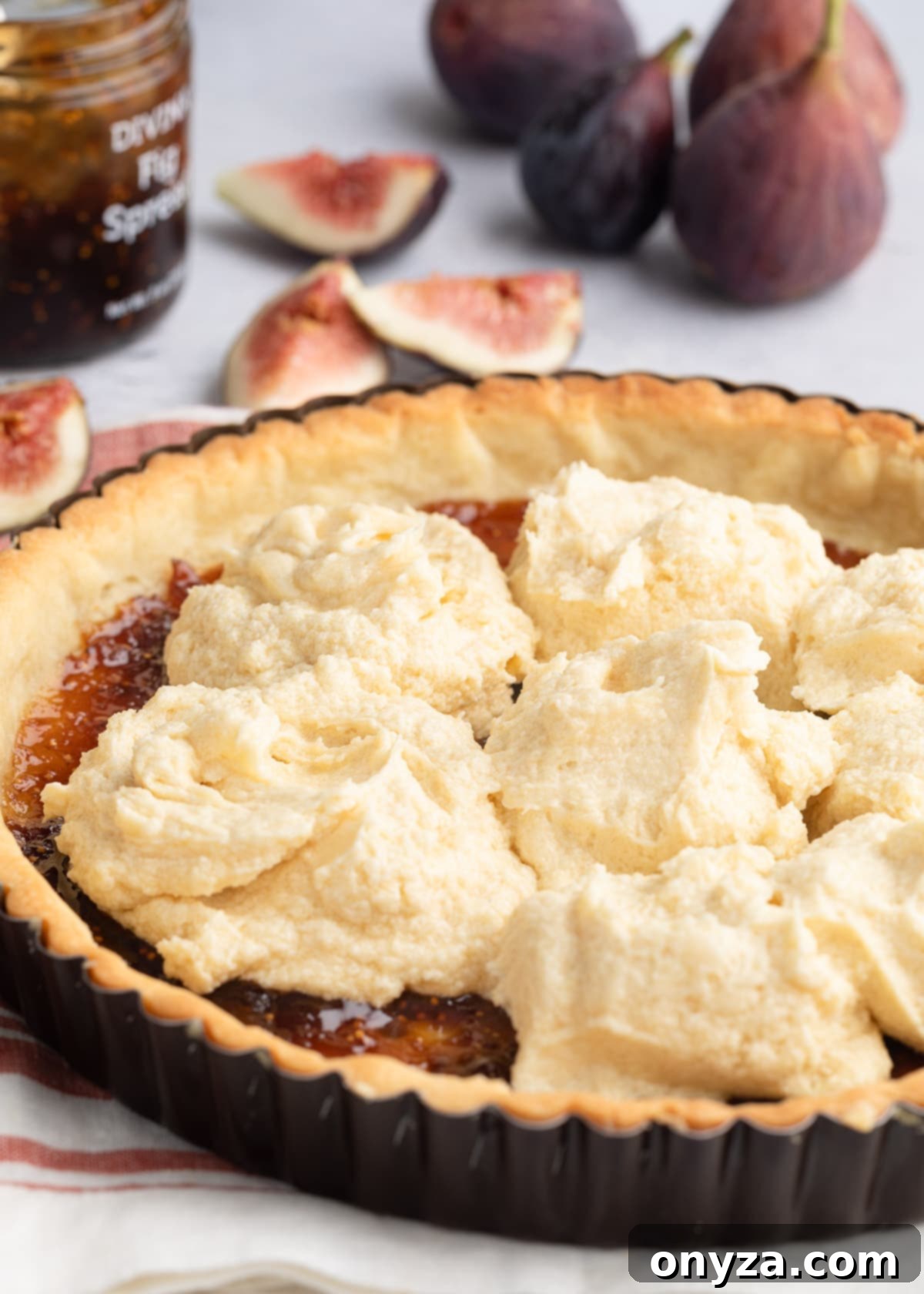 dollops of almond cream in a par-baked tart shell spread with fig jam