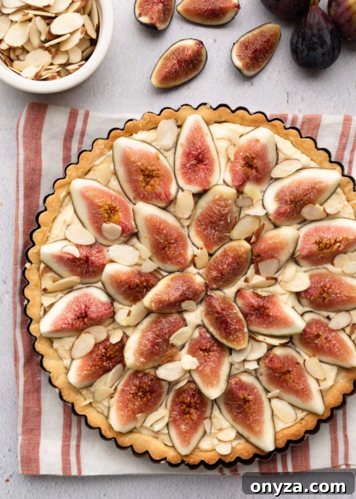 overhead of an unbaked fig tart on a red and white striped napkin