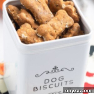 Wholesome Pumpkin Apple Oat Treats for Pups 8 Homemade pumpkin dog treats in a white dog biscuit canister, surrounded by the key ingredients like pumpkin, apples, and oats, showcasing their wholesome nature.