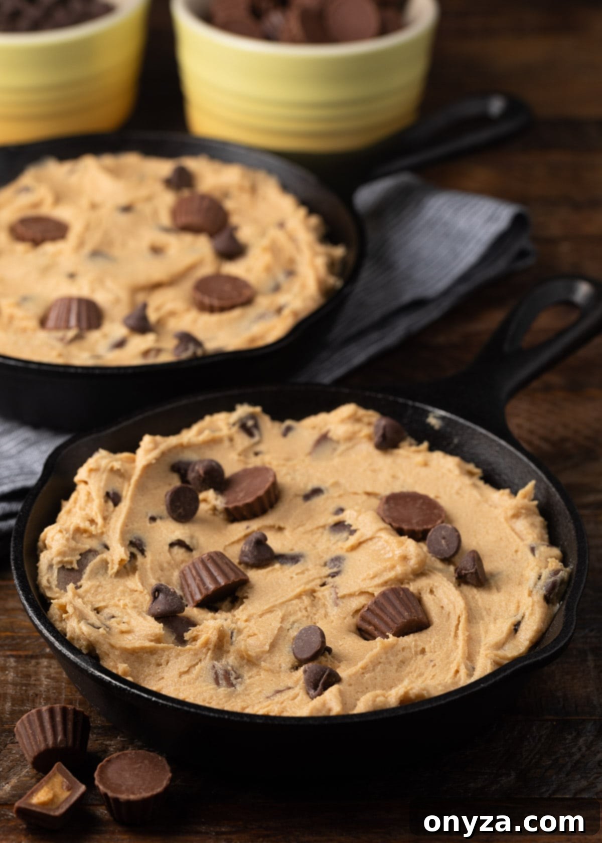 two small cast iron skillets filled with peanut butter cup cookie dough