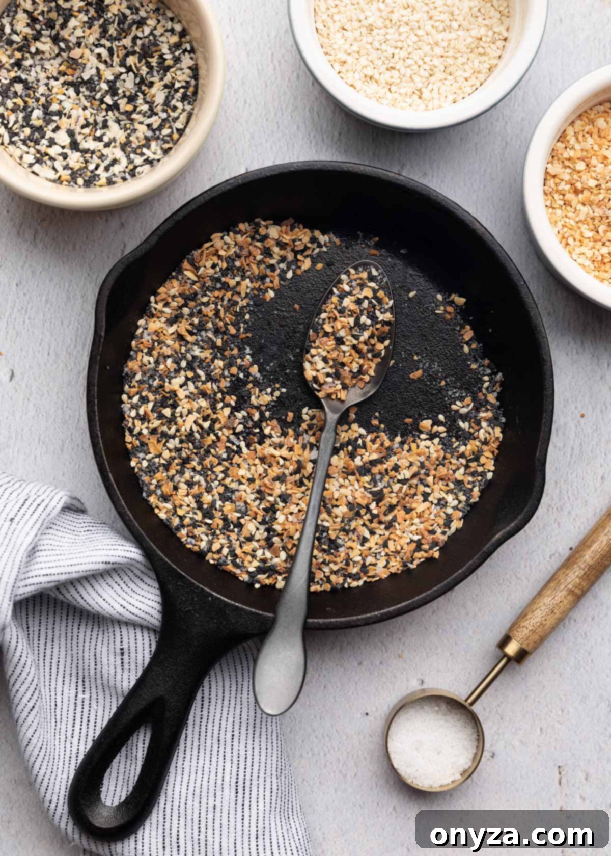 Ultimate Everything Seasoning 5 toasted everything spice in a cast iron skillet with a black spoon
