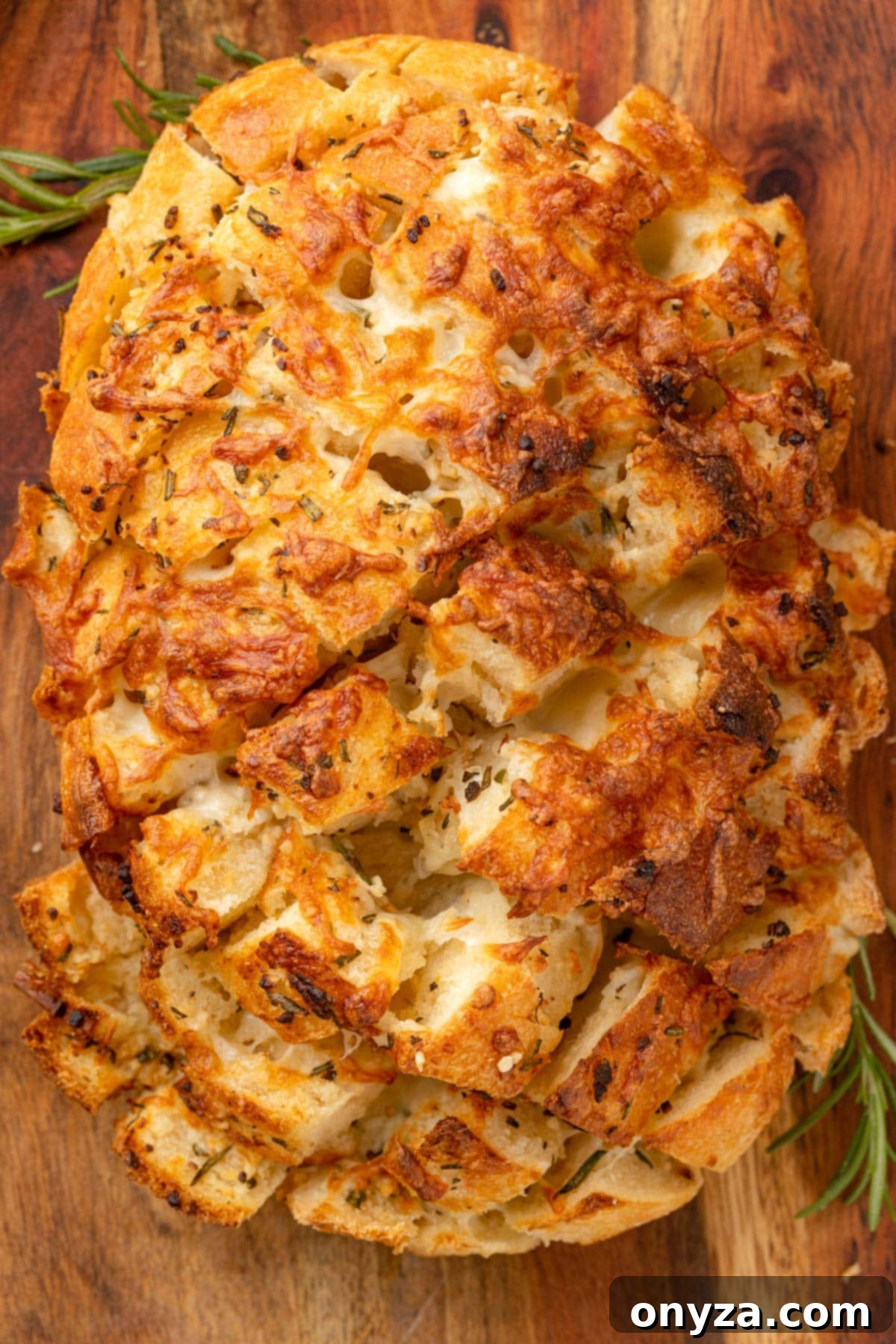 overhead photo of cheesy garlic pull apart bread on a wooden cutting board, ready to be enjoyed