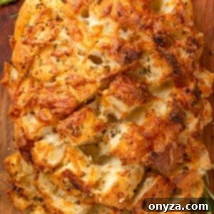 overhead photo of cheesy garlic pull apart bread on a wooden cutting board