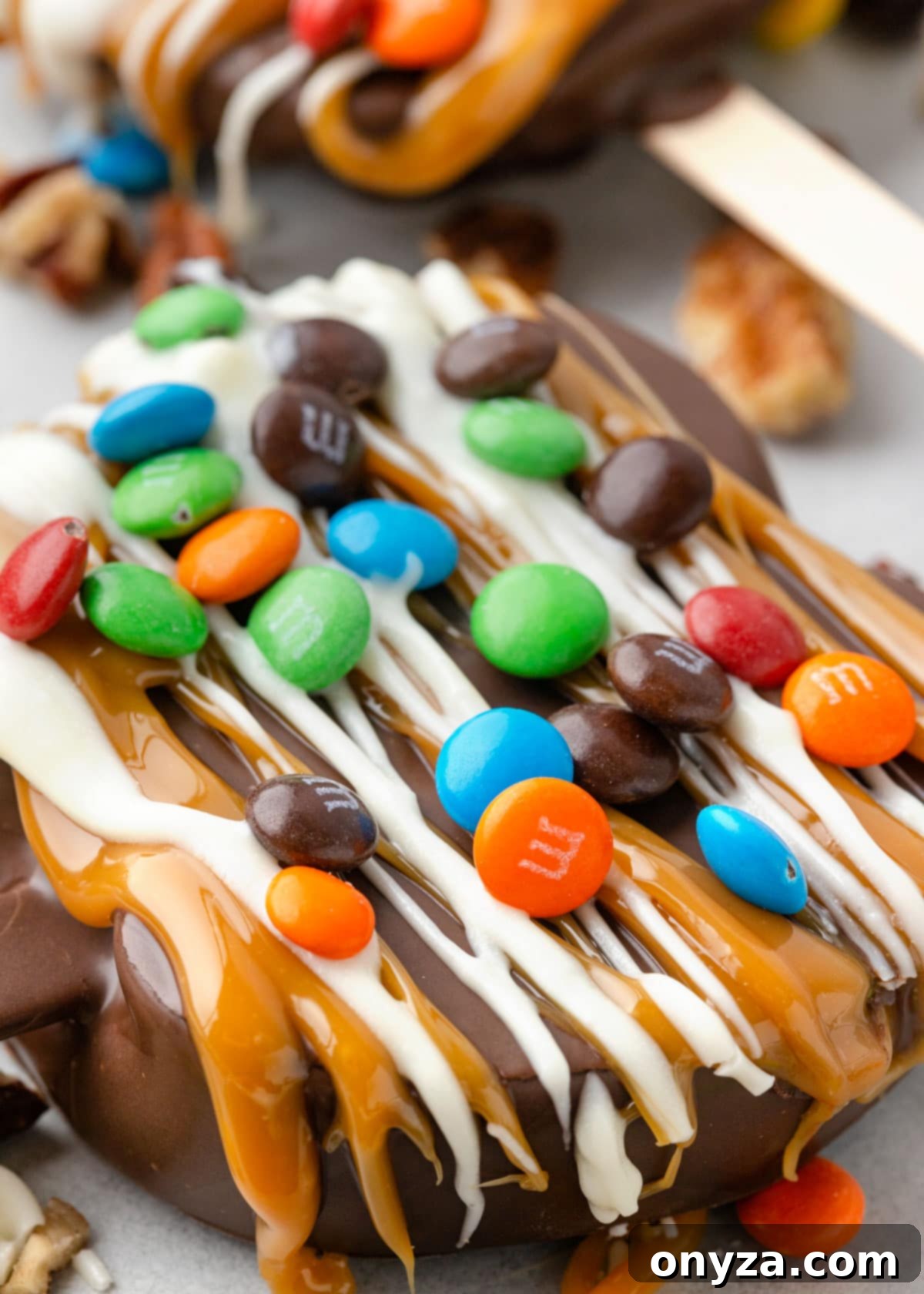 close up of chocolate covered caramel apple slices decorated with mini M&M candies
