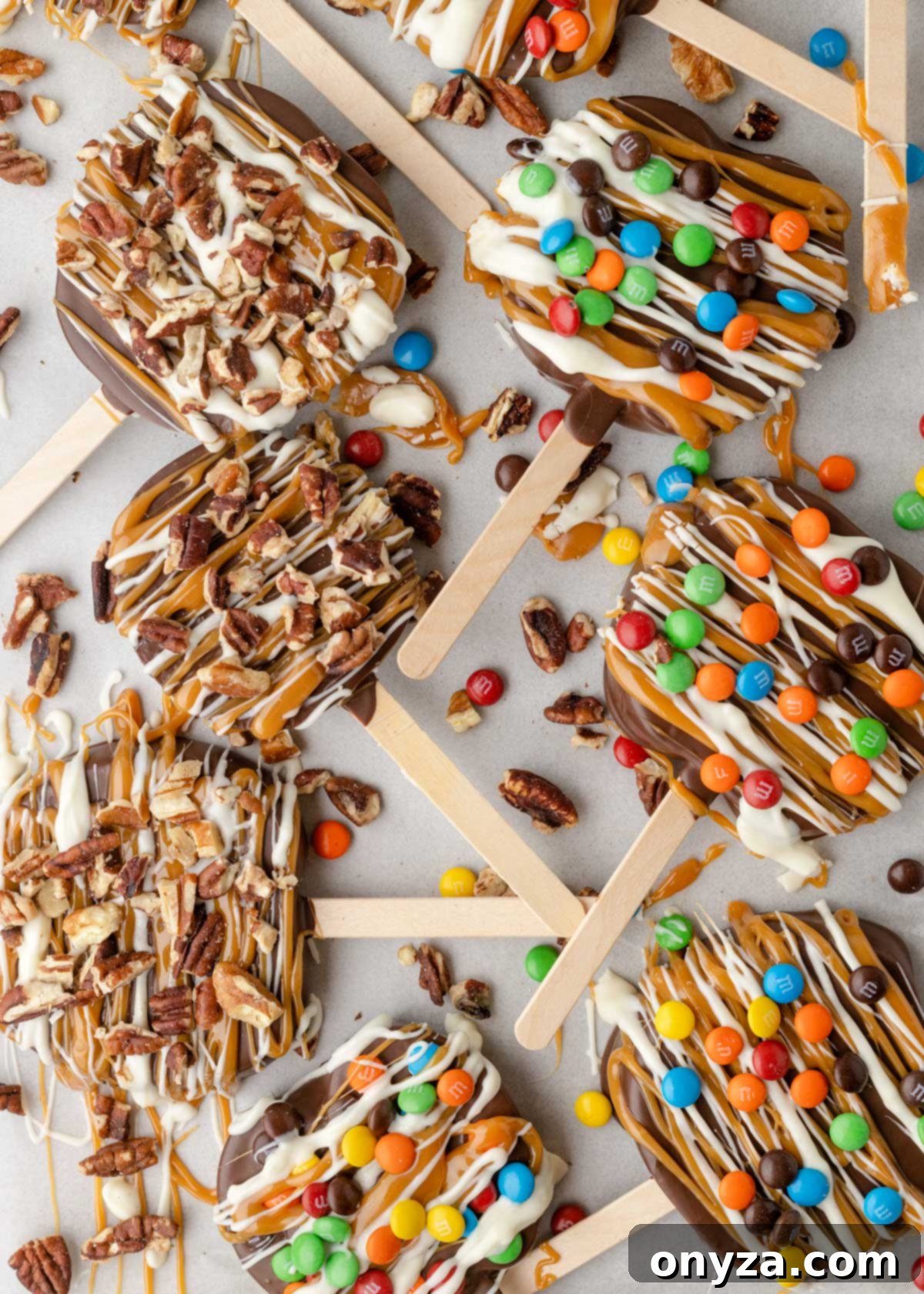 caramel apple slices on a parchment lined baking sheet with pecans and M&M's