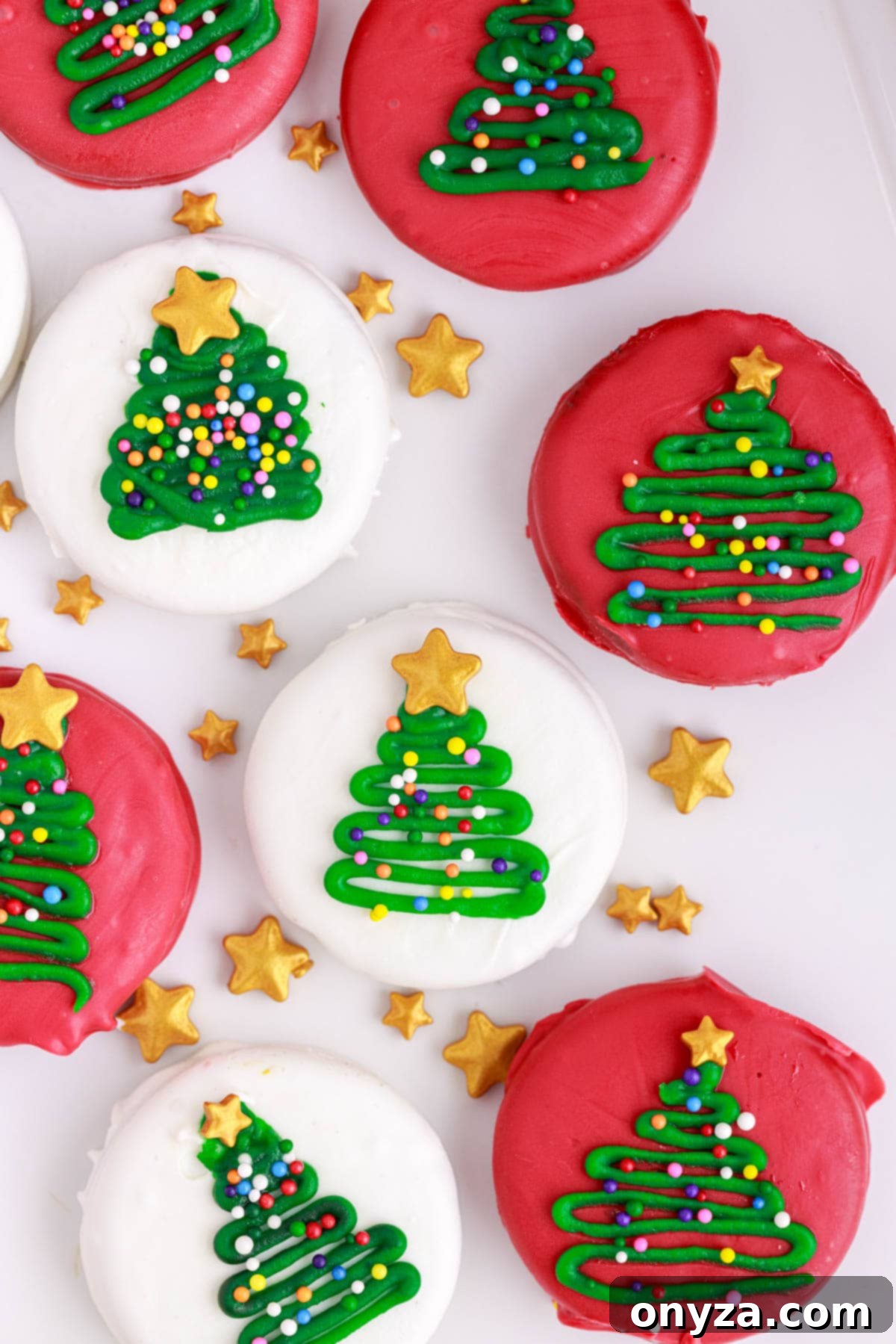 overhead of dipped oreo christmas tree cookies on a white background