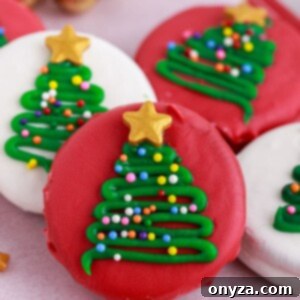red and white candy coated oreos with christmas tree decorations on a parchment-lined platter