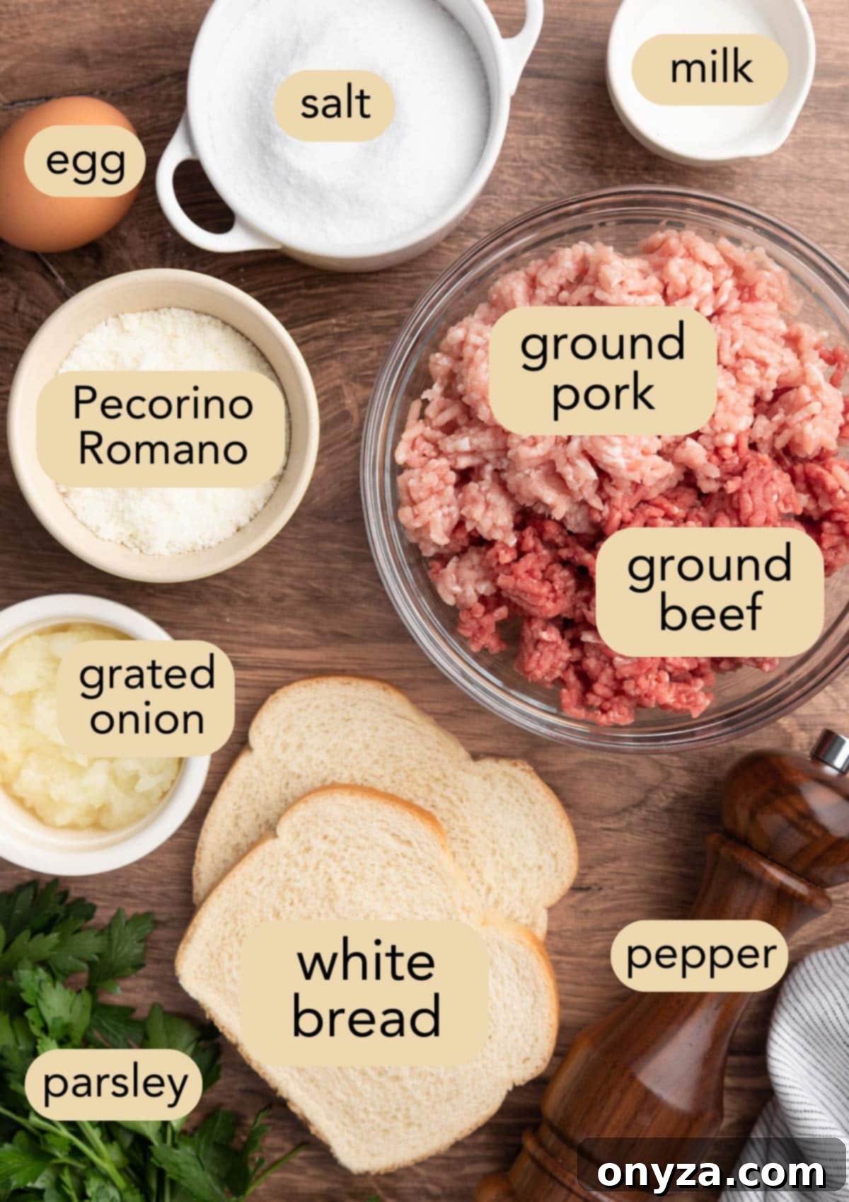 Overhead shot of various ingredients for homemade meatballs for Italian Wedding Soup, including ground meat, bread, cheese, and herbs.