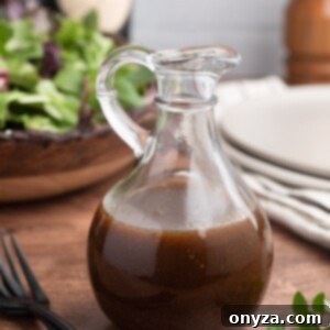 Tangy Balsamic Dressing 6 Homemade Balsamic Vinaigrette in a glass cruet in front of a bowl of spring mix lettuce