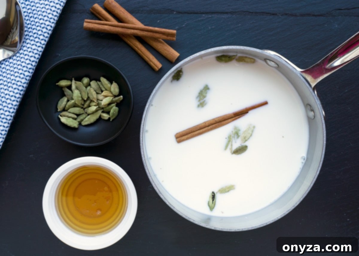 An inviting overhead view of milk gently simmering in a saucepan, adorned with a fragrant cinnamon stick and green cardamom pods, surrounded by bowls of golden honey and more spices, promising a comforting homemade beverage.