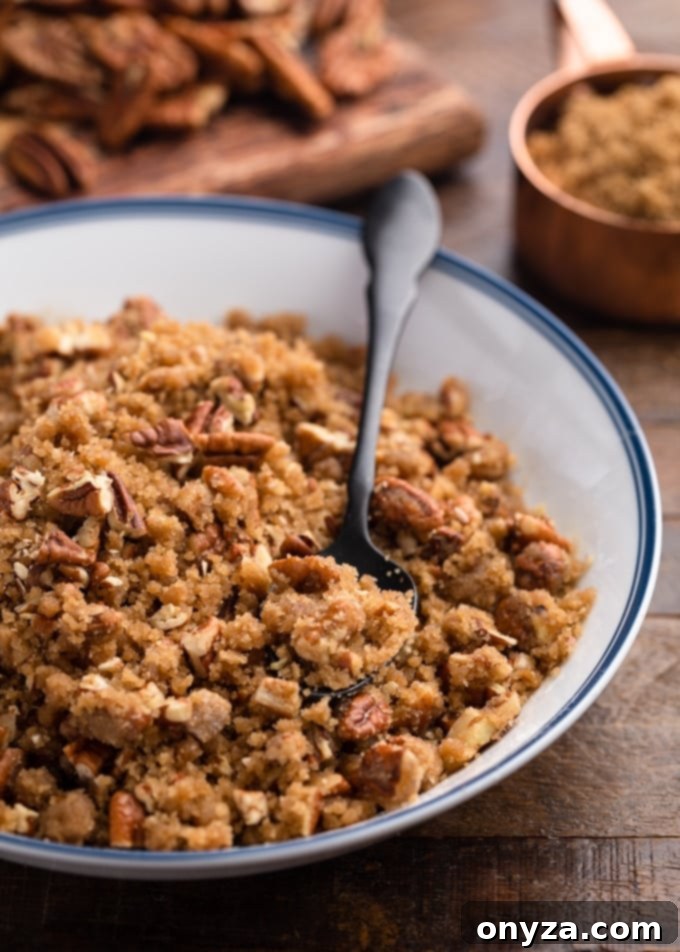 pecan streusel topping in a white and blue bowl with a black spoon