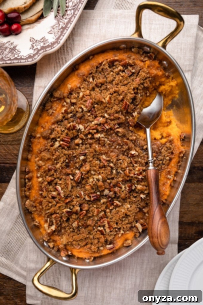 overhead of sweet potato casserole in a gratin pan on a Thanksgiving table
