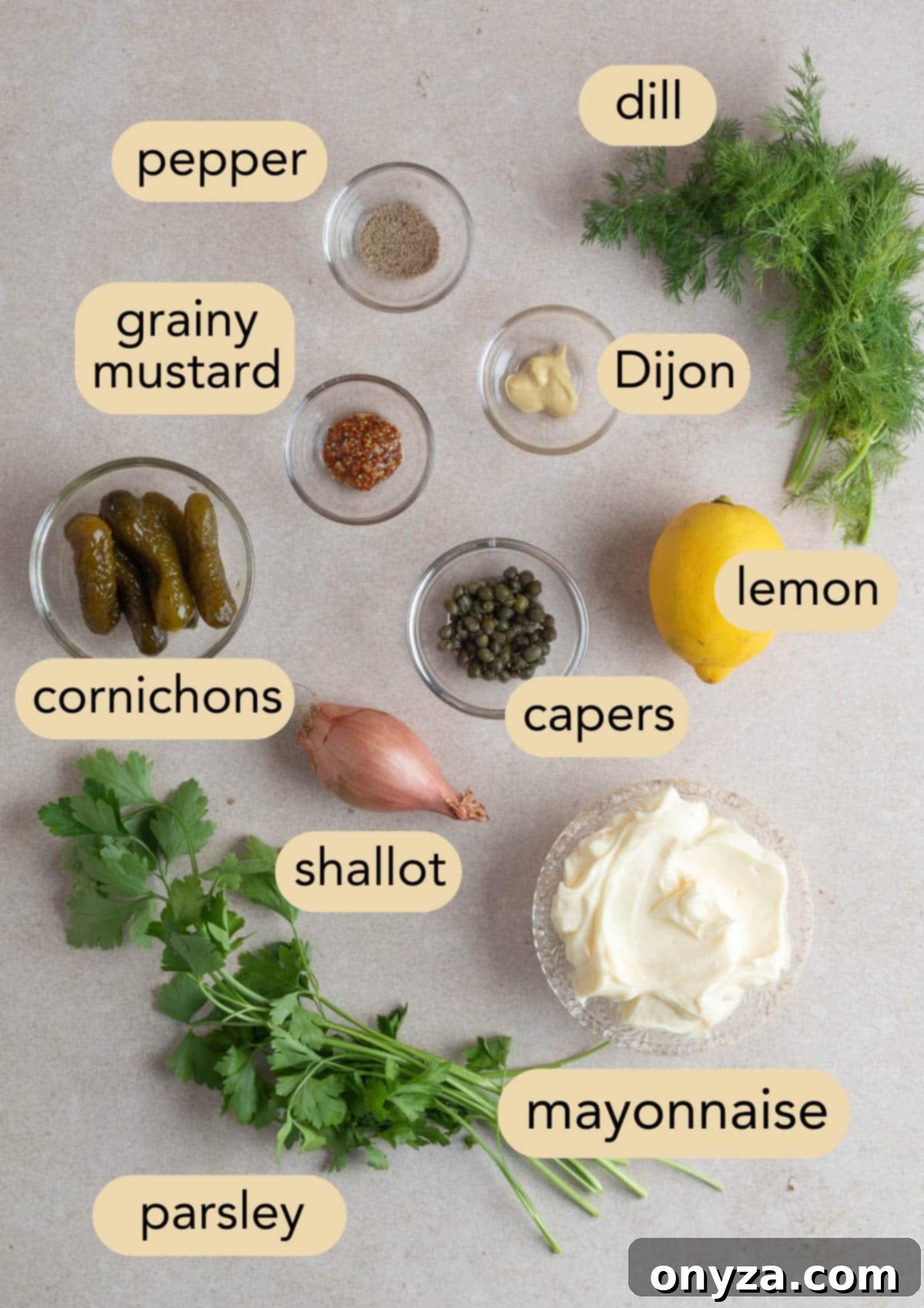 An overhead view of all the fresh, high-quality ingredients required to prepare a batch of tangy tartar sauce. Each ingredient is neatly arranged in individual small bowls, with clear text labels overlaying each component for easy identification.