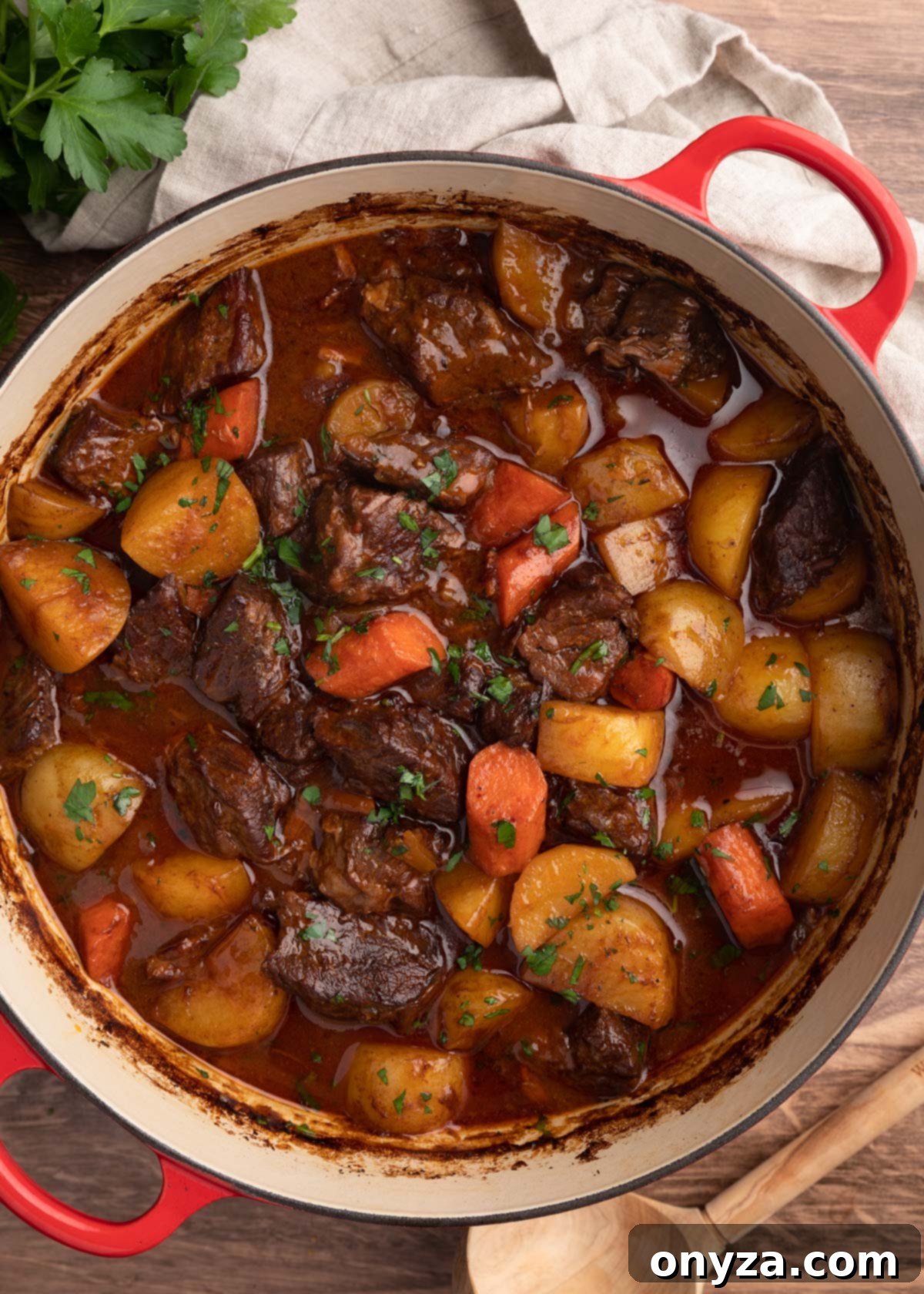 Slow-Cooked Guinness Beef Stew 6 overhead photo of cooked Guinness Beef Stew with potatoes and carrots in a Dutch oven