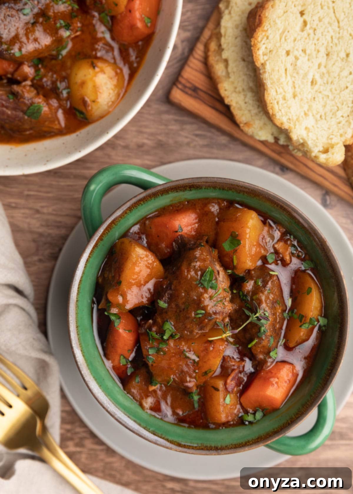 Slow-Cooked Guinness Beef Stew 8 overhead photo of Guinness beef stew with root vegetables in a green double handled crock