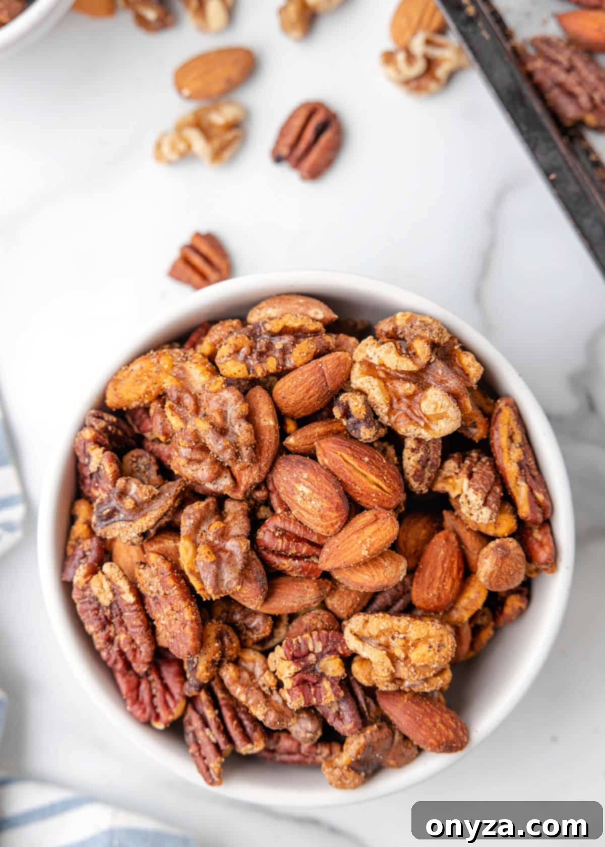 A vibrant bowl of Cajun spicy mixed nuts resting on an elegant marble board, ready to be served as a delicious snack.