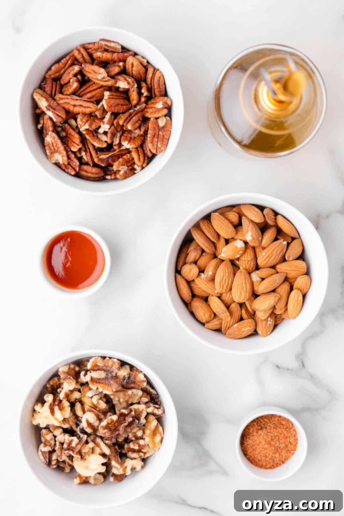An overhead view of various ingredients in small bowls, laid out neatly, showcasing everything needed to create a batch of Cajun spicy mixed nuts.