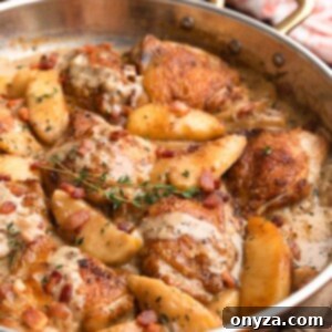 Cider-Braised Chicken with Crispy Bacon and Apples 8 Side view of hard cider chicken with bacon and apples in a copper frying pan